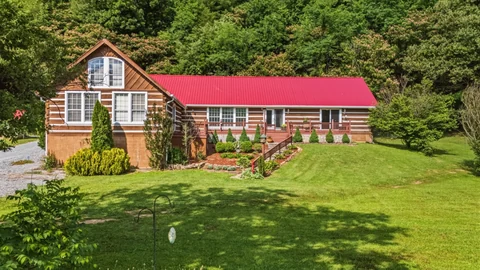 Wood-sided home with a red roof and lawn