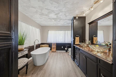 Bathroom with white freestanding tub and double vessel sinks